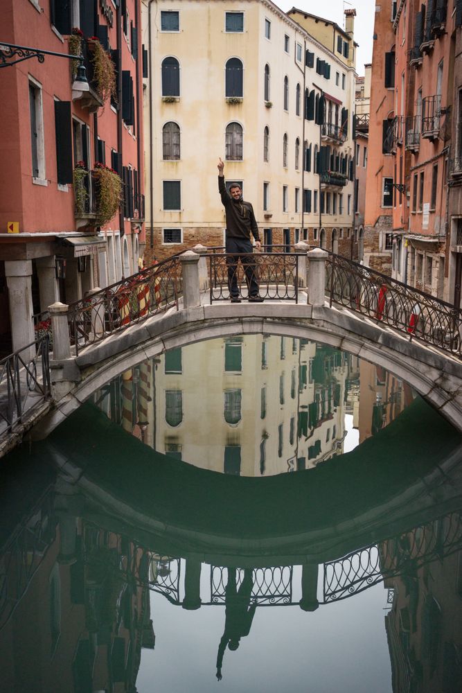 Satisfied resting man delighting in vacation on small bridge above waterway
