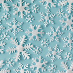 Winter pattern made of different sized snowflakes on blue background