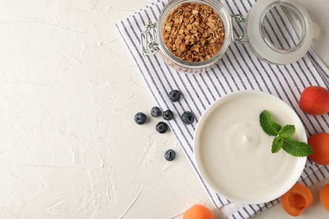 Composition with granola, yogurt and fresh fruits on cement background