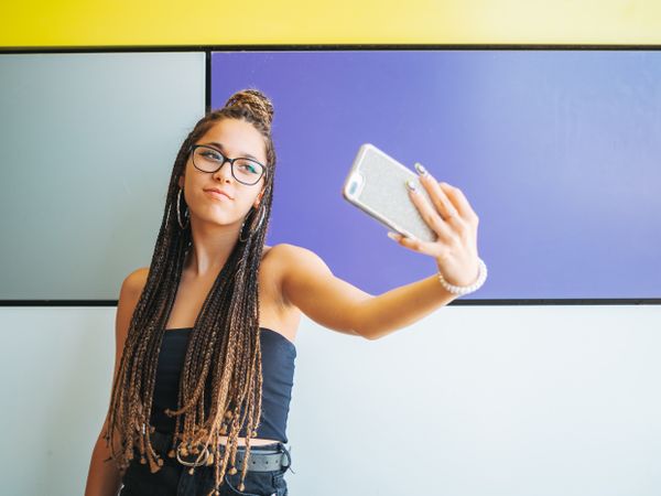Woman with dreadlocks in glasses taking selfie