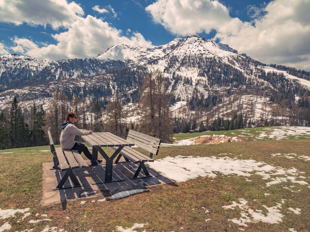 Woman sitting on bench in open air and looking at amazing landscape