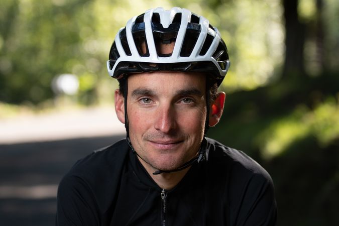 Positive cyclist looking at camera in park