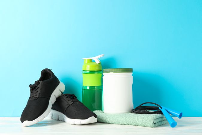 Sport lifestyle accessories on wooden table against blue background