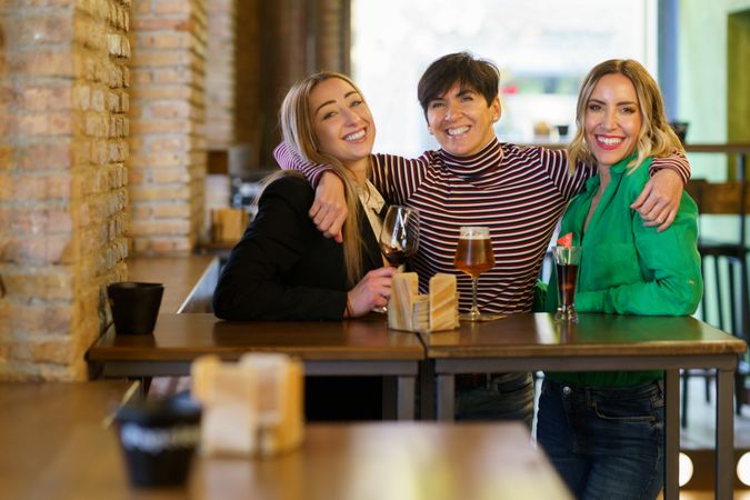Smiling female friends posing for photograph in bar
