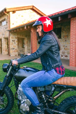 Woman with helmet riding custom motorbike