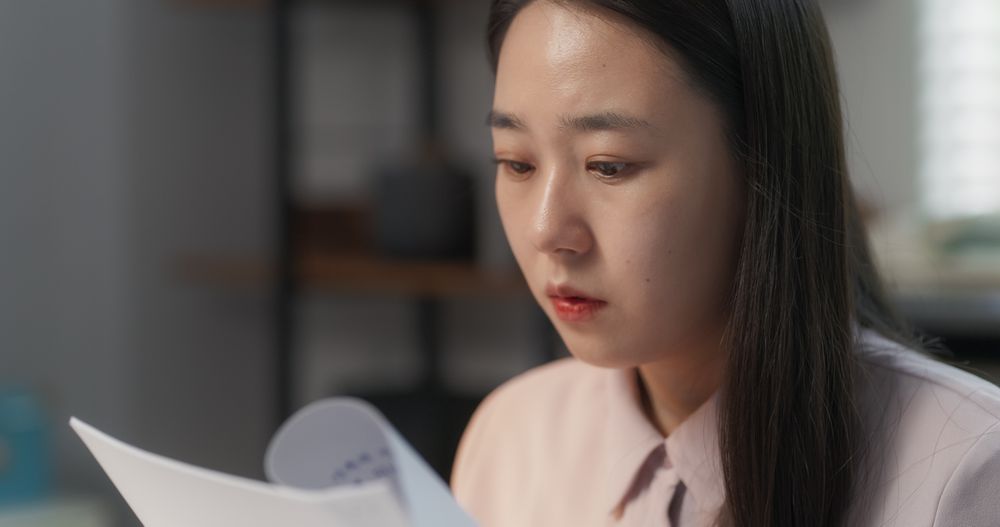 Close Up Portrait of a Female Asian Project Manager Working on a Laptop Computer in a Creative Agency Office