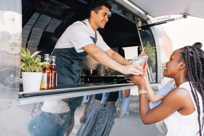 Female buying drink from smiling food truck vendor