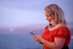 Cheerful body positive woman using smartphone