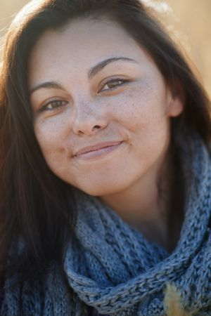 Young adult woman outdoors smiling and looking at camera