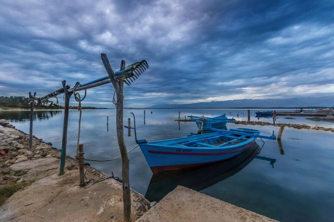 Boat on shore under cloudy sky