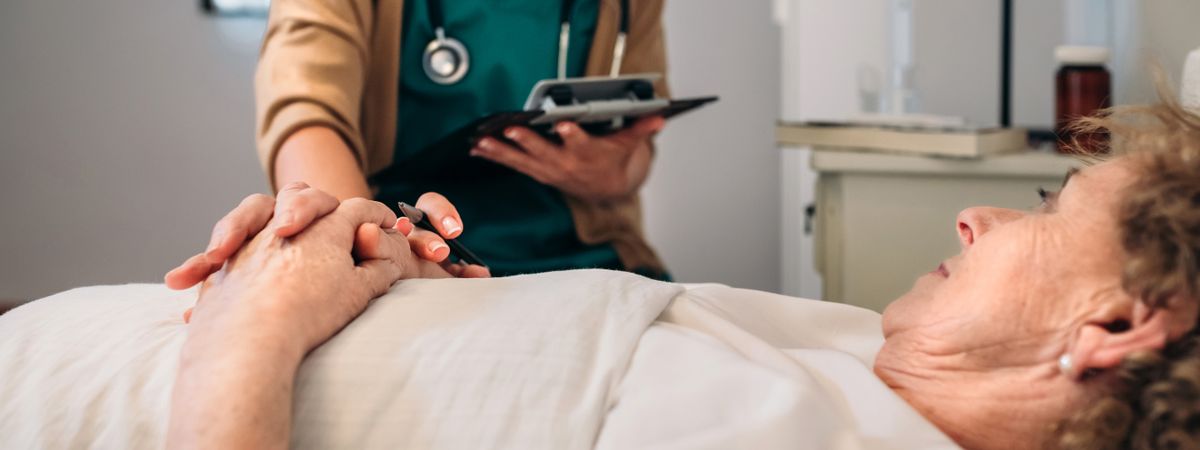 Female doctor comforting older patient