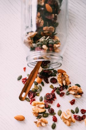 Clear mason jar storing a holiday mix of cranberry, nuts and seeds