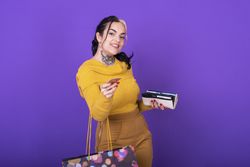 A women holding her wallet and shopping bag while showing a credit card.