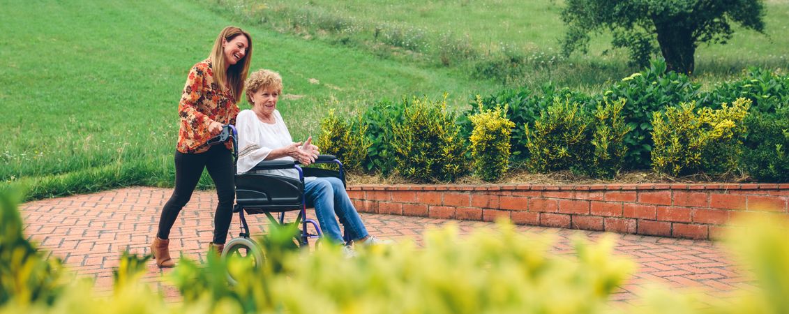 Woman pushing her mother in a wheelchair