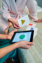 Female doctor showing geometric shapes to older patient