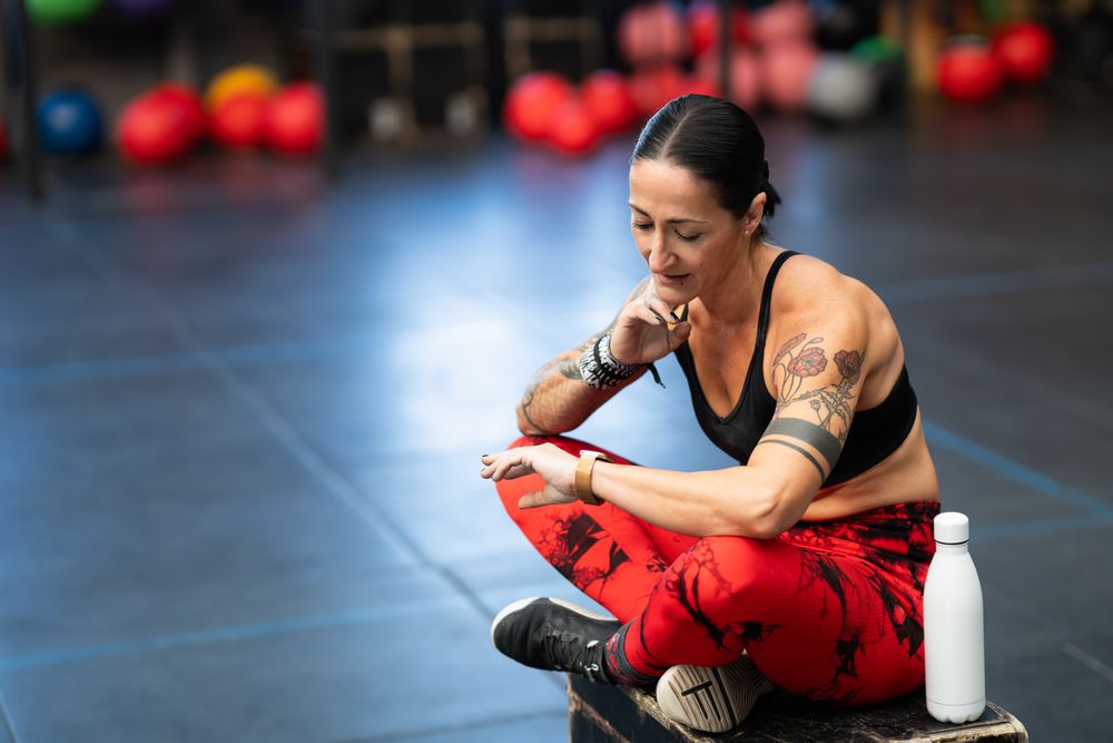 Fit woman checking stats on fitness tracker watch