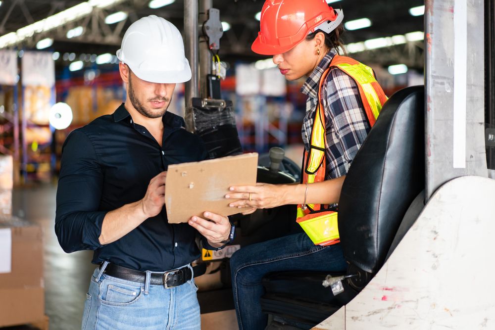 Two colleagues going through list in distribution center