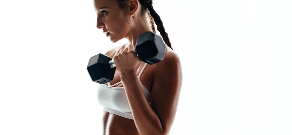 Strong and muscular female exercising with weights