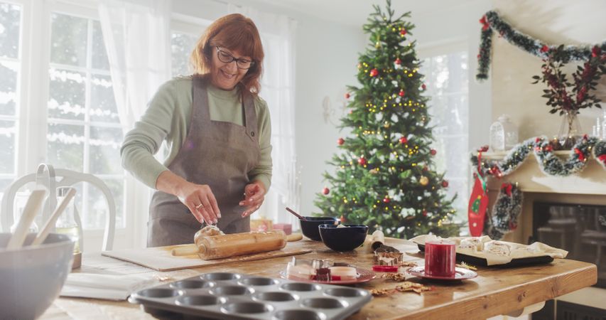 Portrait of Mature Female Making Gingerbread Cookies for Christmas at Home.