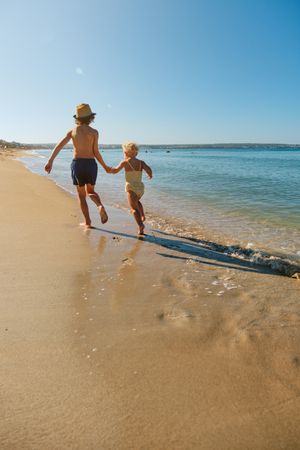 Children running and holding hands at seaside