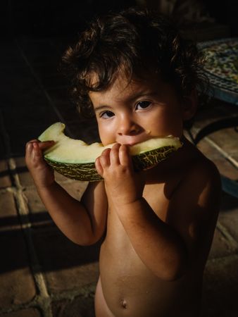 little girl eating melon