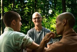 Older man training martial arts student in forest