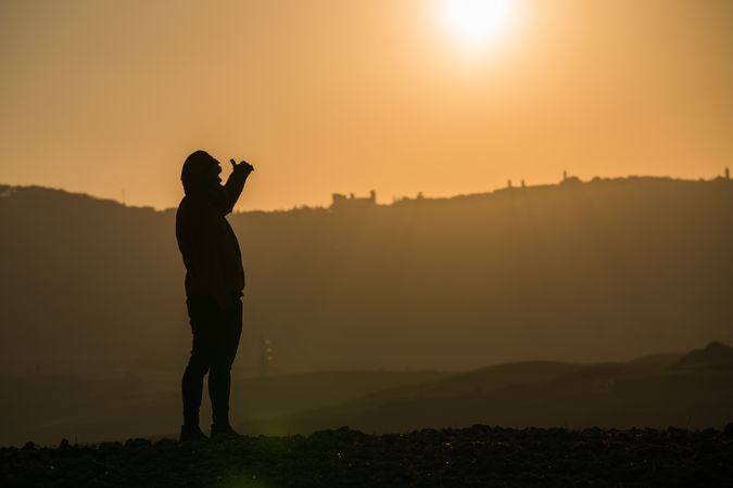 Traveler on field in sunset light