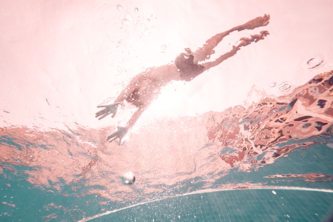 Anonymous man swimming in clear pool water