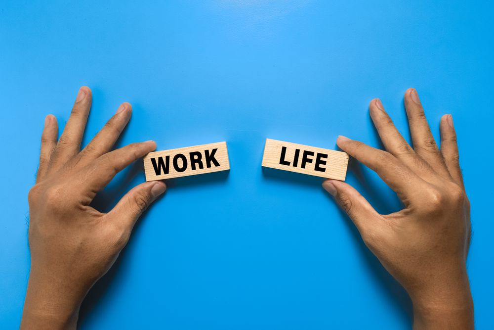 male hand hold work and life words on wooden blocks. isolated on blue background
