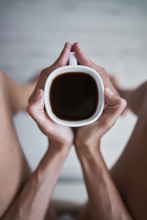 Faceless woman showing coffee cup in hands