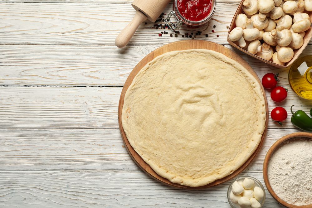 Concept for cooking pizza with ingredients on wooden table