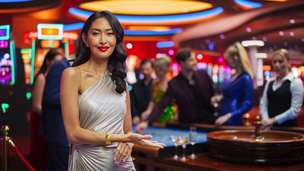 In a Modern Casino Hall: Asian Brunette Woman Posing Confidently, Looking at Camera, Pointing at a Placeholder Space