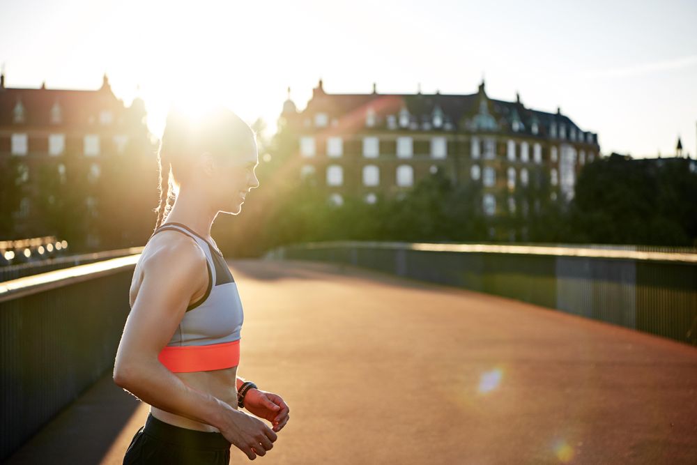 Side view of fit woman smiling in the morning sun
