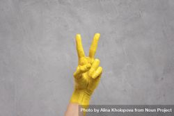 Hand painted yellow giving the peace sign on gray background for Pantone color of 2021 5R89Jb
