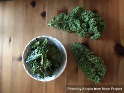 A bowl of kale on wooden table 0LJ7X4