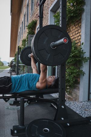 Man lifting barbell on street