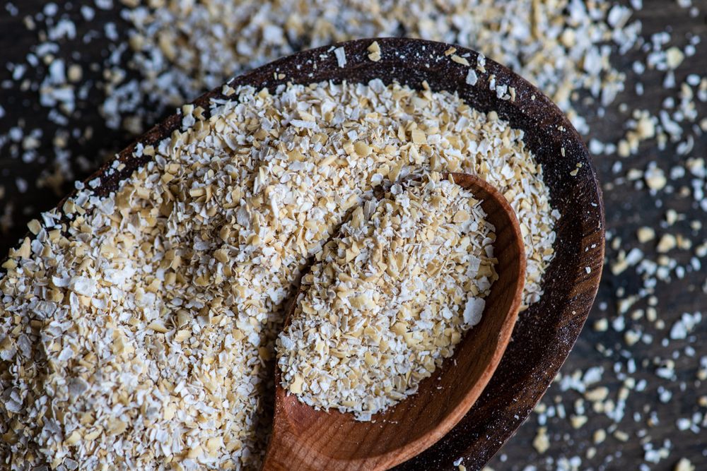 Ground oats with wooden spoon