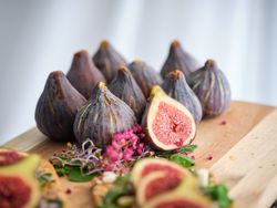 Ripe figs on cutting board with pink flowers