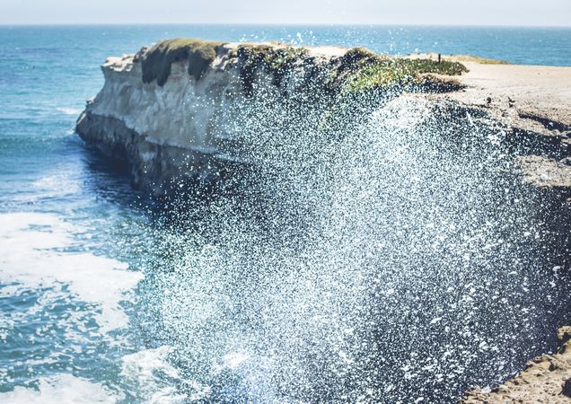 Water with splashes near coast in sunny day