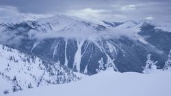 Hills with snow and clouds between mountains