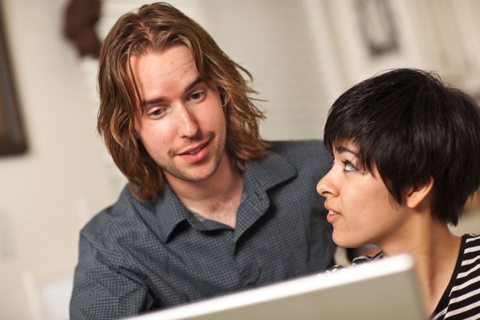 Happy Young Man and Woman Using Laptop Together