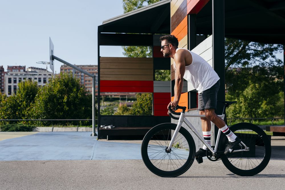 Man riding bike next to buildings