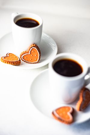 Close up of two espressos with mini heart cookies