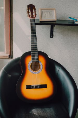 Acoustic guitar on leather chair
