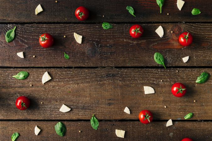 Basil, tomatoes, and cheese on wooden background