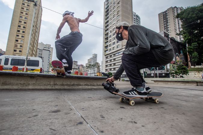 Two men with facemasks on skateboard