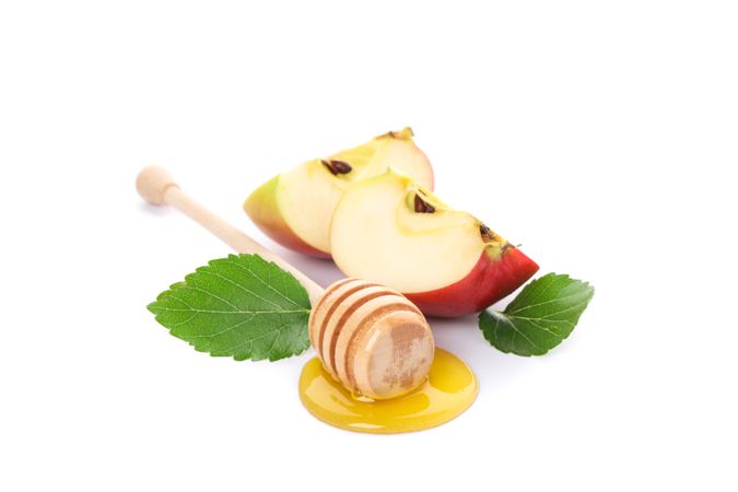 Apple pieces, leaves and dipper with honey isolated on neutral background