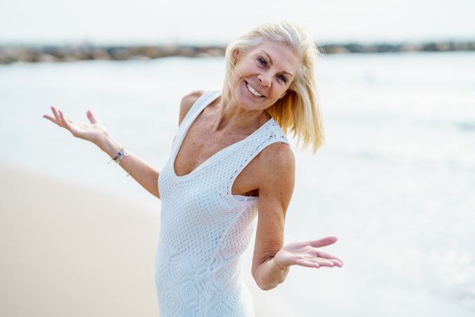 Smiling older woman with her arms making questioning gesture