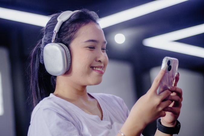 Connected youth: A cheerful woman enjoying music and social media