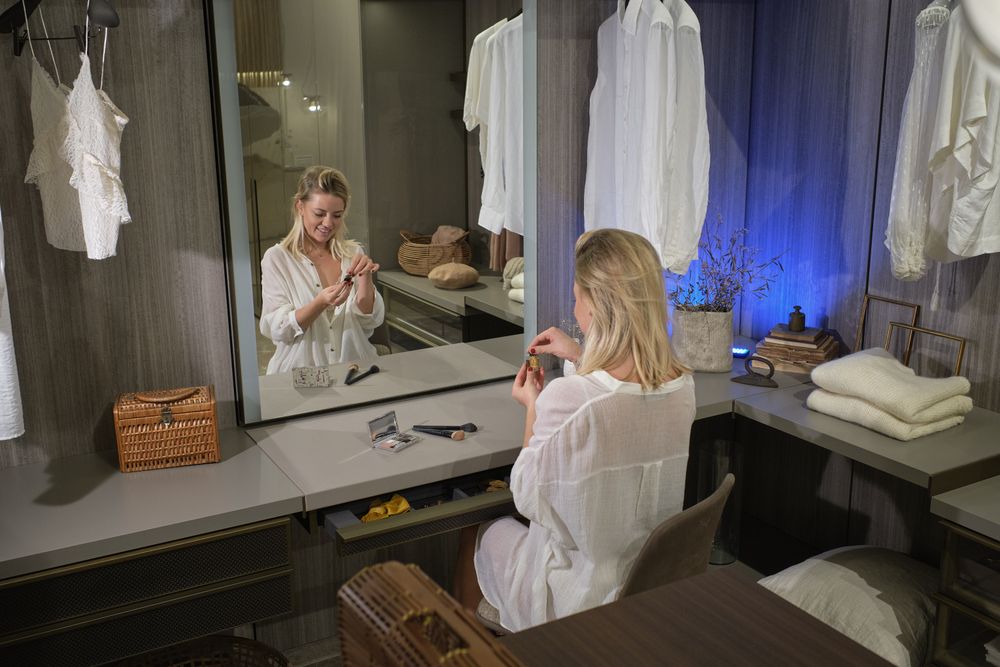 Woman sitting at dressing table and holding perfume